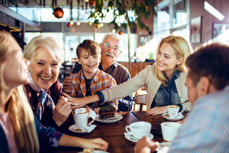 Family enjoying coffee and treats in a cozy cafe under christmas decorations