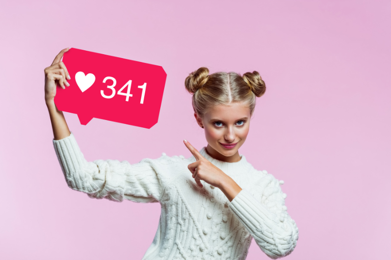 Girl with space buns pointing to a sign of 341 likes